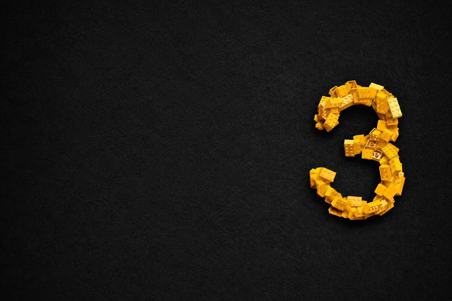 A number three built from yellow construction bricks